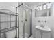 Bathroom showcasing a glass-enclosed shower, modern vanity, and convenient shelving for storage at 3919 W Paxton Ave, Tampa, FL 33611