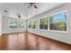 Bright living room features hardwood floors, three windows, and ceiling fans at 3919 W Paxton Ave, Tampa, FL 33611
