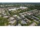 An aerial view highlighting a residential area with mature trees, nearby retail, and diverse single-Gathering homes at 4039 La Pasida Ln, New Port Richey, FL 34655
