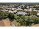 Aerial view shows single-story home community with mature trees, and neighboring landscape at 4039 La Pasida Ln, New Port Richey, FL 34655