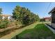 Landscaped backyard with a canal running beside the property at 4039 La Pasida Ln, New Port Richey, FL 34655
