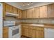 A classic kitchen with wooden cabinetry, white appliances, and tile backsplash at 4039 La Pasida Ln, New Port Richey, FL 34655