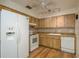 The kitchen has wooden cabinets, tile backsplash, white appliances, and ceiling fan at 4039 La Pasida Ln, New Port Richey, FL 34655