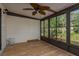 Bright sunroom with wood-look floors, a ceiling fan, and large screened windows at 4039 La Pasida Ln, New Port Richey, FL 34655