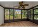 Enclosed sunroom with a ceiling fan and large windows offering outdoor views at 4039 La Pasida Ln, New Port Richey, FL 34655