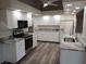 Bright kitchen featuring white cabinetry, stainless steel appliances, and gray granite countertops at 405 Lemonwood Dr, Englewood, FL 34223