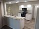 Open kitchen with granite countertops, stainless steel appliances, and a breakfast bar at 405 Lemonwood Dr, Englewood, FL 34223