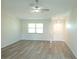 Bright, open-concept living area with new light wood-look flooring, white walls and ceiling fan at 405 Lemonwood Dr, Englewood, FL 34223