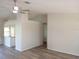 Bright, open-concept living area with new light wood-look flooring, white walls and kitchen access at 405 Lemonwood Dr, Englewood, FL 34223