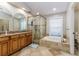 A well-lit bathroom with a walk-in shower, tub, and double sink vanity at 447 Bridle Path Way, Tarpon Springs, FL 34688