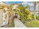 Close up of the front door and entrance way, lush landscaping, and a brick path walkway at 447 Bridle Path Way, Tarpon Springs, FL 34688