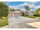 Attractive single-story home shows a well-maintained lawn, mature trees, and an expansive driveway at 447 Bridle Path Way, Tarpon Springs, FL 34688