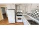 Efficient kitchen layout with white appliances, white cabinets, and laminate flooring at 4851 W Gandy Blvd # B7L23, Tampa, FL 33611