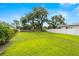 Spacious green backyard with mature trees and a white fence, perfect for outdoor enjoyment at 5800 3Rd S St, St Petersburg, FL 33705