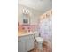 Clean, pink bathroom with a white vanity and a seashell-patterned shower curtain at 5800 3Rd S St, St Petersburg, FL 33705