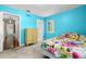 Bright blue bedroom with light carpet, a dresser, and access to the rest of the house at 5800 3Rd S St, St Petersburg, FL 33705