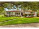 Charming single-story home with vibrant landscaping, well-maintained lawn, and mature shade tree at 5800 3Rd S St, St Petersburg, FL 33705