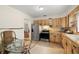 Well-lit kitchen features stainless steel appliances, wood cabinets, and glass top table at 5800 3Rd S St, St Petersburg, FL 33705