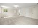 Light-filled living room features gray carpeting, a neutral palette, and multiple windows at 5800 3Rd S St, St Petersburg, FL 33705