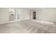 Expansive living room showcasing neutral tones, plush gray carpeting, and multiple entryways at 5800 3Rd S St, St Petersburg, FL 33705