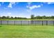 Beautiful backyard featuring a serene pond view and black metal fence, perfect for relaxation at 6097 Golden Nettle Dr, Apollo Beach, FL 33572