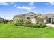 Beautifully landscaped front yard with a charming single-story home, enhanced by green grass and blue skies at 6097 Golden Nettle Dr, Apollo Beach, FL 33572