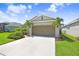 Attractive home with a two-car garage, beautiful lawn, and vibrant landscaping, complemented by a sunny sky at 6097 Golden Nettle Dr, Apollo Beach, FL 33572