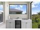 Outdoor kitchen featuring sleek white cabinetry and a built in beverage refrigerator at 6097 Golden Nettle Dr, Apollo Beach, FL 33572
