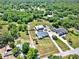 Wide aerial shot showcases this home situated amongst lush greenery with a large metal building on the property at 6219 Wendell Dr, Wesley Chapel, FL 33544
