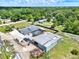 Aerial view of the property showing the home with screened pool, large metal building, and surrounding landscape at 6219 Wendell Dr, Wesley Chapel, FL 33544