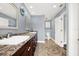 Bright bathroom with double sinks, decorative tile flooring, and an adjacent toilet room at 6219 Wendell Dr, Wesley Chapel, FL 33544