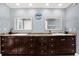 Large bathroom featuring a double sink vanity, decorative mirrors, and stylish fixtures at 6219 Wendell Dr, Wesley Chapel, FL 33544