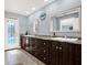 Spacious bathroom featuring dual sinks, a granite countertop, and a decorative glass door at 6219 Wendell Dr, Wesley Chapel, FL 33544