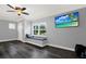 Bright bedroom with hardwood floors, a window seat, and a mounted television at 6219 Wendell Dr, Wesley Chapel, FL 33544