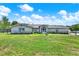 Inviting one-story home with a lush green lawn, mature landscaping, and a screened front entrance at 6219 Wendell Dr, Wesley Chapel, FL 33544