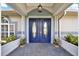 Charming home entrance with double doors, detailed trim, and decorative planters at 6219 Wendell Dr, Wesley Chapel, FL 33544