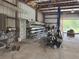 Interior view of metal building with roll up door, heavy equipment, and various metal materials at 6219 Wendell Dr, Wesley Chapel, FL 33544
