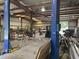 Interior view of a metal building workshop with heavy equipment, tools, and metal stock at 6219 Wendell Dr, Wesley Chapel, FL 33544
