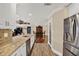 Open concept kitchen with granite counters, stainless appliances, pantry, and hardwood floors leading to dining at 6219 Wendell Dr, Wesley Chapel, FL 33544