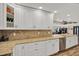 Bright kitchen with granite countertops, white cabinets, stainless steel appliances, and hardwood floors at 6219 Wendell Dr, Wesley Chapel, FL 33544