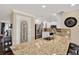 Modern kitchen featuring granite countertops, stainless steel appliances, white cabinetry, and a pantry door at 6219 Wendell Dr, Wesley Chapel, FL 33544