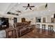 Spacious living area with hardwood floors, leather seating, a wet bar, and access to a dining area at 6219 Wendell Dr, Wesley Chapel, FL 33544
