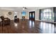 Bright living room with hardwood floors, a fireplace, large windows, and an elegant entry at 6219 Wendell Dr, Wesley Chapel, FL 33544