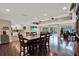 Open-concept living and dining area with hardwood floors, bright lighting, and a view of the screened-in pool at 6219 Wendell Dr, Wesley Chapel, FL 33544