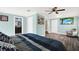 Comfortable main bedroom features a ceiling fan, wood flooring, and a TV with a beach scene at 6219 Wendell Dr, Wesley Chapel, FL 33544