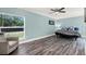 Relaxing main bedroom with wood flooring and a chair for comfortable seating at 6219 Wendell Dr, Wesley Chapel, FL 33544