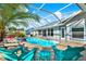 Inviting screened pool area features lounge chairs and tropical landscaping at 6219 Wendell Dr, Wesley Chapel, FL 33544
