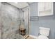 The tiled shower features glass doors and a convenient wooden stool for added comfort at 6219 Wendell Dr, Wesley Chapel, FL 33544