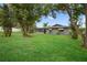 Expansive backyard featuring lush green lawn and mature trees, perfect for outdoor activities and relaxation at 6310 Gainsboro Ave, Spring Hill, FL 34609