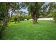 Large backyard features mature trees, a white fence, and plenty of green space at 6310 Gainsboro Ave, Spring Hill, FL 34609